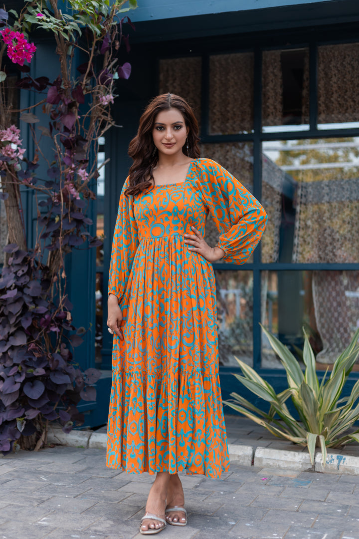 Full-length view of orange and cyan blue floral maxi dress styled with silver accessories