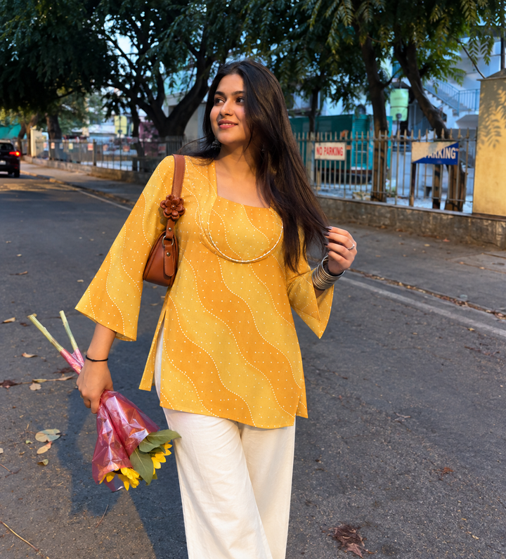 SONA Mustard Wave Short Kurti front view showing rich mustard chanderi kurti with diagonal wave lehar print flared bell sleeves and square neckline with cord trim detail